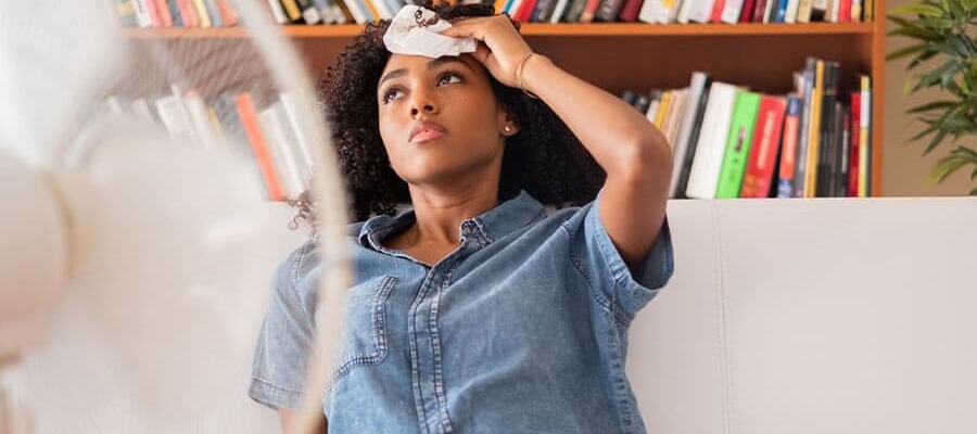 woman sweltering in front of a fan