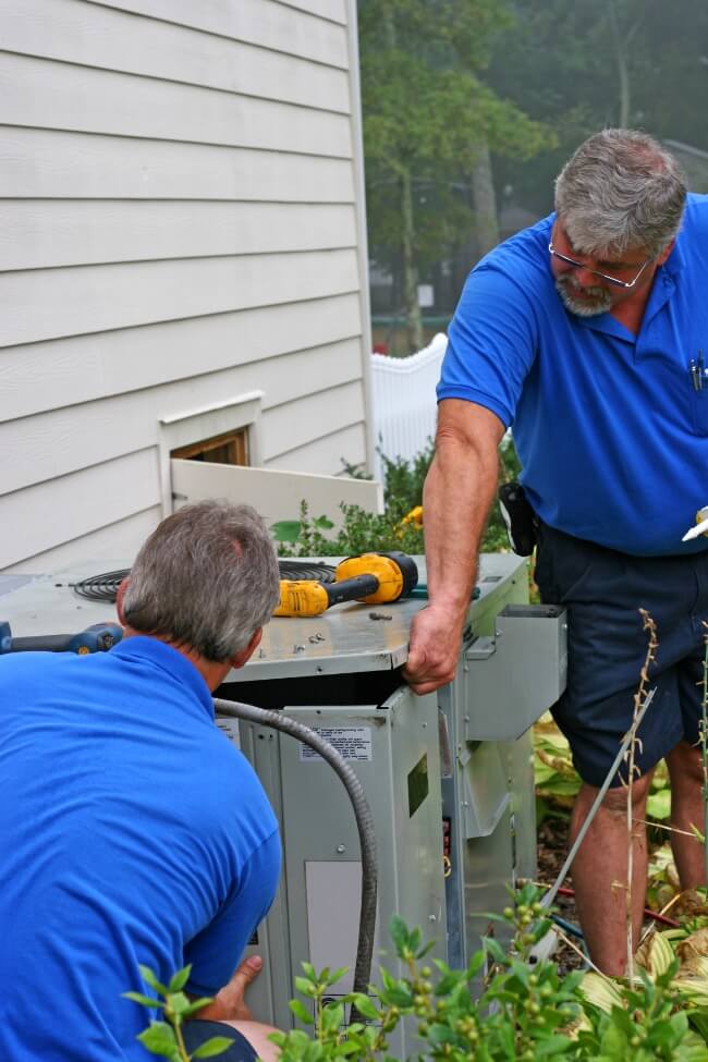 HVAC technicians working on an outdoor ac unit 1