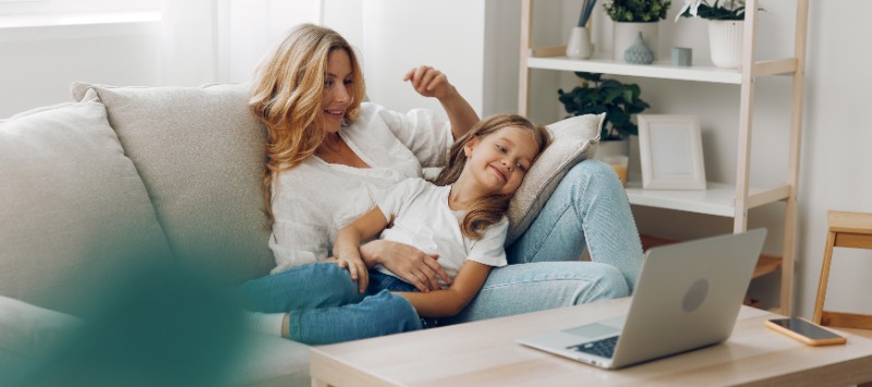 mother and daughter relaxing on sofa